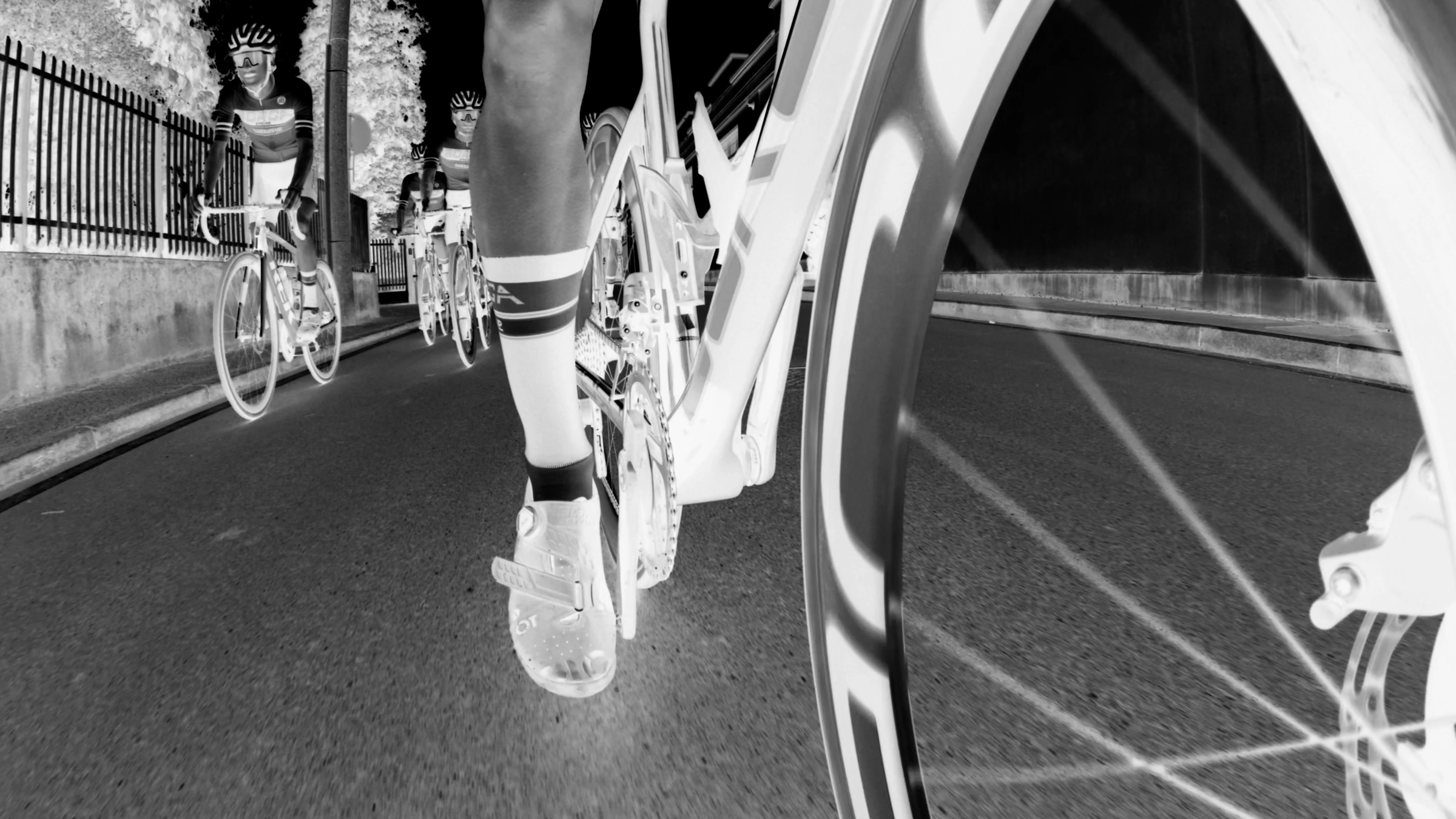 Ciclisti su strada in un frame con effetto negativo